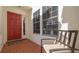 Inviting front entrance with a bright red door, red tile flooring, and a comfortable seating area at 4404 Calle Serena, Sarasota, FL 34238