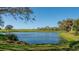 Scenic lake view overlooking a golf course with lush greenery and clear blue skies at 4404 Calle Serena, Sarasota, FL 34238