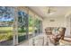 Bright sunroom with seating, large windows, and a tranquil view of the pond and landscape at 4404 Calle Serena, Sarasota, FL 34238
