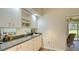 Elegant wet bar with granite countertop, custom cabinets, and decorative lighting at 4404 Calle Serena, Sarasota, FL 34238