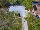 Aerial view showcasing a well-maintained home with a new roof near the waterfront and mature trees at 4453 Meadow Creek Cir, Sarasota, FL 34233