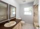 Bathroom with dual mirrors, decorative tile, and beige colored vanity at 4453 Meadow Creek Cir, Sarasota, FL 34233