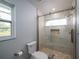 Bathroom featuring a modern shower with glass doors, neutral tile, and a built-in niche at 4453 Meadow Creek Cir, Sarasota, FL 34233