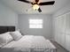Bedroom with white bedding, ceiling fan, and double door closet at 4453 Meadow Creek Cir, Sarasota, FL 34233