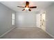 A minimalist bedroom with light gray walls, plush carpet, and a dark ceiling fan at 4453 Meadow Creek Cir, Sarasota, FL 34233