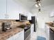 Bright kitchen featuring white cabinetry, stainless steel appliances, and stone countertops at 4453 Meadow Creek Cir, Sarasota, FL 34233