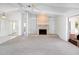 A bright living room features a brick fireplace, neutral carpet, and large sliding doors to the outside at 4453 Meadow Creek Cir, Sarasota, FL 34233