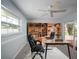 Bright office space with built-in bookcase, large window, and sliding glass door to exterior at 4453 Meadow Creek Cir, Sarasota, FL 34233