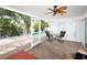 Inviting sunroom with tile floor overlooks the pool and water views at 4453 Meadow Creek Cir, Sarasota, FL 34233