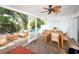 Inviting sunroom with outdoor seating and ceiling fan overlooks the pool and water views at 4453 Meadow Creek Cir, Sarasota, FL 34233