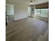 Sunlit bedroom with neutral tones, wood-look flooring, glass door, and a view of the outdoors at 4460 Fairways Blvd # 304, Bradenton, FL 34209