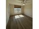 Bright bedroom with sleek wood floors, ceiling fan, and a large window showcasing green outdoor scenery at 4460 Fairways Blvd # 304, Bradenton, FL 34209
