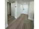 Well-lit hallway with neutral-toned walls and wood-look flooring, with multiple doors, including a closet at 4460 Fairways Blvd # 304, Bradenton, FL 34209