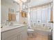Bright bathroom with a shower-tub combo, neutral tile, and decorative palm tree shower curtain at 4464 Mcintosh Lake Ave, Sarasota, FL 34233