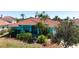 Charming teal home with a red tile roof, lush landscaping, and a welcoming front entrance at 4464 Mcintosh Lake Ave, Sarasota, FL 34233