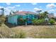 Charming home featuring a blue exterior, lush landscaping, and a vibrant red tile roof at 4464 Mcintosh Lake Ave, Sarasota, FL 34233