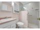 Bathroom features pink walls, a quartz countertop, a vanity, and glass door shower at 4933 Rutland Gate, Sarasota, FL 34235