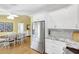 Open kitchen and dining area, featuring stainless steel appliances, white cabinets, and an oval table at 4933 Rutland Gate, Sarasota, FL 34235