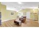 Spacious living room with hardwood flooring, light yellow walls, a ceiling fan, and a comfortable recliner at 4933 Rutland Gate, Sarasota, FL 34235