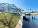 Lush lawn leading to a private dock with boat access, complete with a screened enclosure at 5016 Mangrove Point Rd, Bradenton, FL 34210