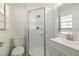 Bright bathroom showcasing glass door shower, tile, white toilet, and a modern sink at 510 Marlin Dr, Punta Gorda, FL 33950