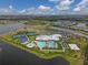 Aerial view of resort-style community amenities including swimming pools, tennis courts, and clubhouse, surrounded by lakes at 5311 White Sand Cv, Bradenton, FL 34211