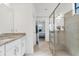 Bathroom with glass shower, dual vanity and mirrors, tile floors, and access to bedroom at 5311 White Sand Cv, Bradenton, FL 34211