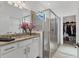 Bright bathroom with a granite countertop, a glass shower, and a view to the walk-in closet at 5311 White Sand Cv, Bradenton, FL 34211