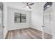 Bright bedroom featuring wood-look floors and white walls with large windows and ceiling fan at 5311 White Sand Cv, Bradenton, FL 34211