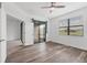 This bedroom boasts wood-look floors, a ceiling fan, and a sliding glass door at 5311 White Sand Cv, Bradenton, FL 34211
