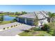 Aerial view of home featuring a three-car garage, a grey tile roof, and a beautiful waterfront view at 5311 White Sand Cv, Bradenton, FL 34211