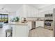 Kitchen featuring white cabinetry, granite countertops, stainless steel appliances, and an eat-in bar at 5311 White Sand Cv, Bradenton, FL 34211