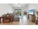 Bright living room featuring an open floor plan, neutral tile, comfortable furnishings, and access to the outdoor living space at 5311 White Sand Cv, Bradenton, FL 34211