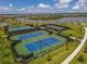 Aerial shot of community tennis courts showcasing meticulously maintained landscaping, with lakes and neighborhood views at 5311 White Sand Cv, Bradenton, FL 34211