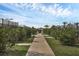 Scenic walking path lined with lush greenery, benches, and views of the surrounding tennis courts at 5311 White Sand Cv, Bradenton, FL 34211