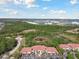 Expansive aerial view of this neighborhood and its well-maintained apartment buildings with terracotta roofs, surrounded by mature trees at 5401 Bentgrass Dr # 1-302, Sarasota, FL 34235