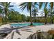 Beautiful community pool surrounded by mature palm trees and landscaping for a relaxing oasis at 5401 Bentgrass Dr # 1-302, Sarasota, FL 34235