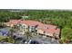 Modern low-rise apartment buildings featuring tan siding and eye-catching terracotta tile roofs and lush green landscaping at 5401 Bentgrass Dr # 1-302, Sarasota, FL 34235
