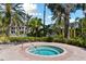 Inviting community hot tub with clear blue water, surrounded by tropical landscaping and palm trees at 5401 Bentgrass Dr # 1-302, Sarasota, FL 34235