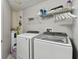Bright laundry room with modern washer and dryer, storage shelves and a water heater at 5401 Bentgrass Dr # 1-302, Sarasota, FL 34235