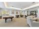 Spacious recreation room with seating, tables, a pool table, and access to outdoor patios at 5401 Bentgrass Dr # 1-302, Sarasota, FL 34235