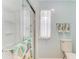 Bathroom with a white shower, toilet, window, and decorative towels hanging nearby at 5619 Bayshore Rd # 107, Palmetto, FL 34221