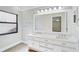 Bathroom featuring double sink vanity, large mirror, and wood-look tile flooring at 6017 Marella Dr, Sarasota, FL 34243