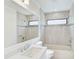 Bathroom featuring single vanity with tile surround, window, and combined tub and shower at 6017 Marella Dr, Sarasota, FL 34243