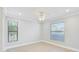 Bright bedroom with a ceiling fan, two windows and light wood flooring at 6017 Marella Dr, Sarasota, FL 34243