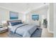 Comfortable bedroom boasting a vaulted ceiling, ceiling fan, plush bedding, and calming ocean-themed artwork at 6017 Marella Dr, Sarasota, FL 34243