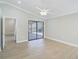 Light-filled main bedroom with tile floors, ceiling fan, vaulted ceiling, and sliding door access at 6017 Marella Dr, Sarasota, FL 34243