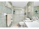 Bright bathroom featuring a glass-enclosed shower, toilet, and a towel rack with decorative towels at 612 Bird Bay S Dr # 116, Venice, FL 34285
