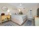 Bright bedroom with modern ceiling fan, blue accent rugs, and updated gray flooring at 612 Bird Bay S Dr # 116, Venice, FL 34285