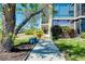 Building entrance with glass doors, lush landscaping, and a sidewalk at 612 Bird Bay S Dr # 116, Venice, FL 34285